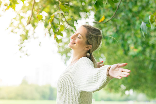 Une femme qui ouvre les bras dans la nature