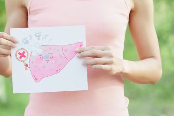 Une femme tenant une photo d'un foie dans la main.
