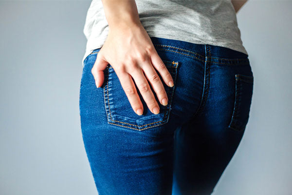 Une femme ayant une main sur ses fesses.
