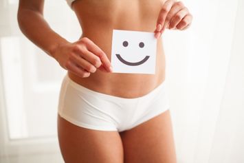 Une femme tenant un post-it avec un sourire.