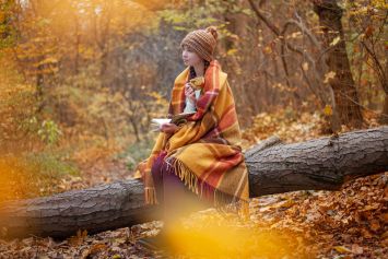 Une femme assise sur un tronc d'arbre.