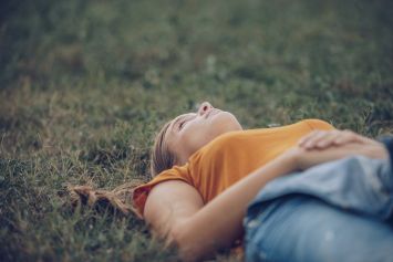 Une femme allongé par terre dans l'herbe