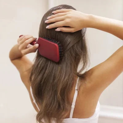 Femme qui se coiffe les cheveux