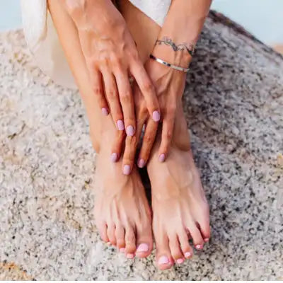 Mains posées sur les pieds, pour illustrer les soins naturels des mains et des pieds.