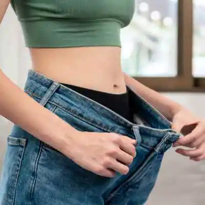 Femme mince qui tire sur son jean