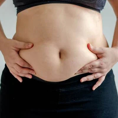 Femme touchant son ventre montrant ses rondeurs 