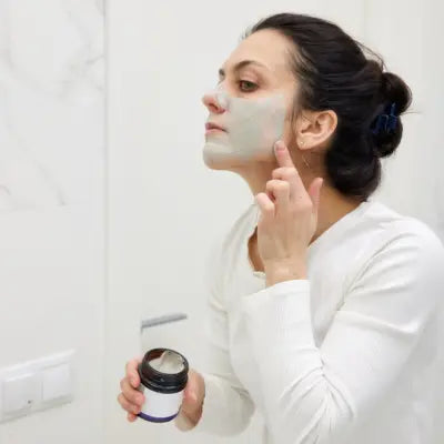 Femme qui s'applique un soin sur le visage