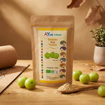 Poudre Amalaki Bio Ayurvana 150g avec fruits amla frais sur surface bois, cadre wellness