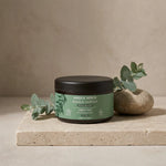 Pot d'argile verte Najel sur vanité spa minimaliste avec éléments botaniques naturels