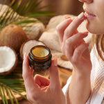 Baume à lèvres coco bio Najel en pot verre ambré, application sur lèvres, texture crémeuse