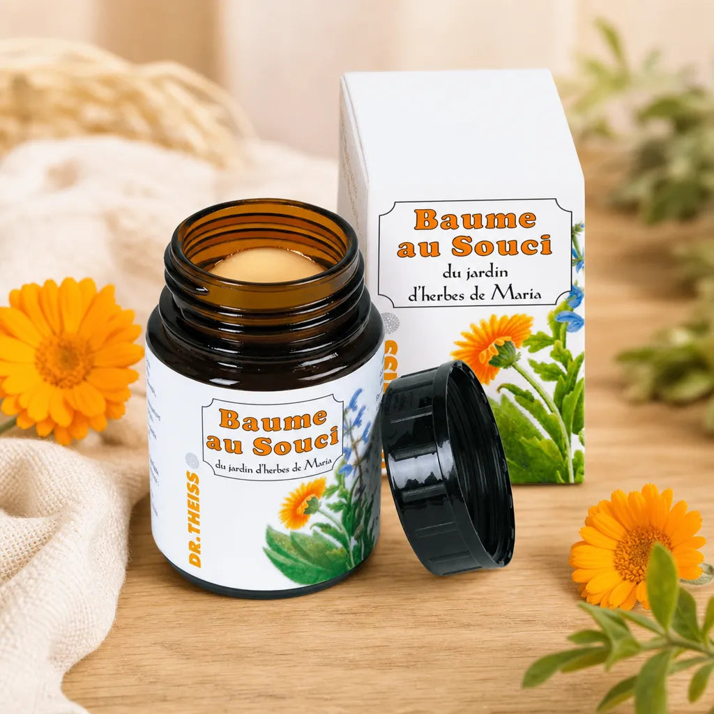 Baume au Souci Dr Theiss en pot de verre ambré avec fleurs de calendula fraîches sur surface bois