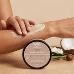 Femme appliquant le baume coco bio Najel sur sa peau sèche, pot noir avec texture crémeuse visible