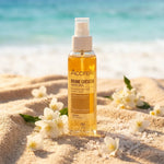 Brume Protectrice Cheveux Bio Acorelle flacon sur plage avec fleurs et cristaux de sel