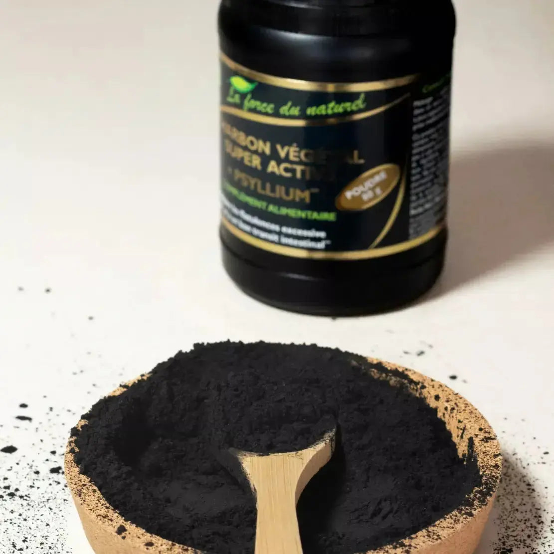 de la poudre de Charbon Végétal Super Activé + Psyllium Bio dans une coupelle en bois avec une cuillère
