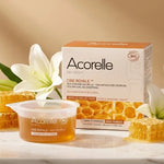Cire royale bio Acorelle sans bande sur vanité marbre avec fleurs, packaging visible