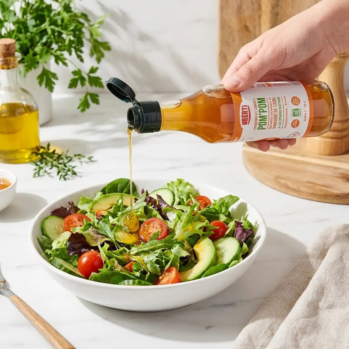 Condiment Pom'Pom bio versé sur salade verte fraîche en cuisine