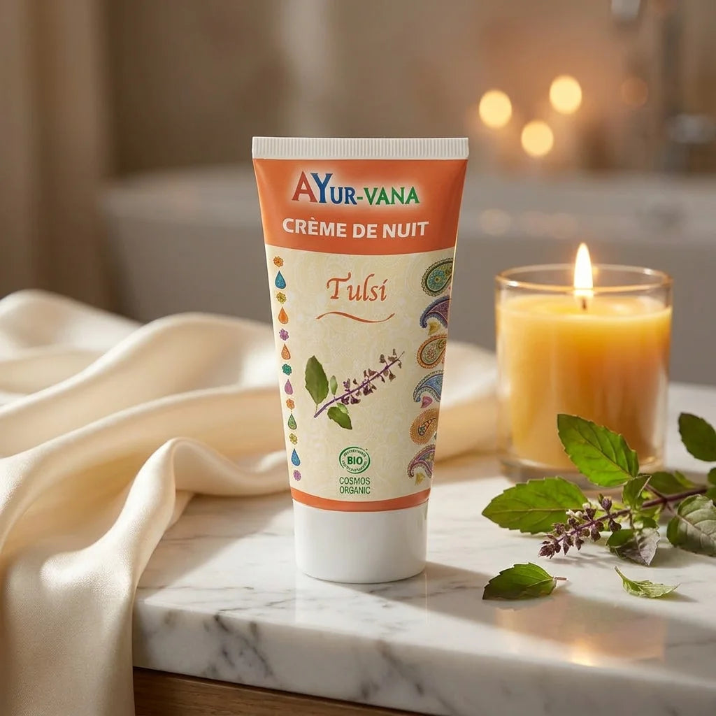 Crème de nuit Tulsi bio Ayurvana sur vanité en marbre avec feuilles de tulsi et bougie