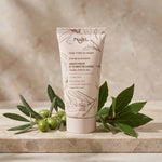 Tube de crème hydratante bio Najel sur marbre avec branches d'olivier et laurier