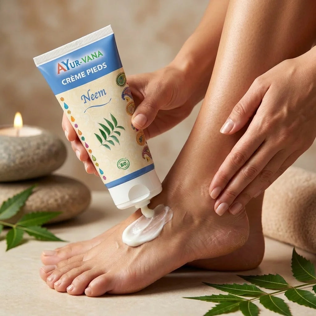 Femme appliquant crème pieds Neem bio Ayurvana sur talons secs, tube bleu beige visible