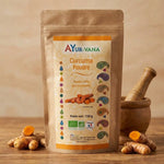 Curcuma Bio Ayur-vana en poudre avec racines fraîches et mortier sur surface bois