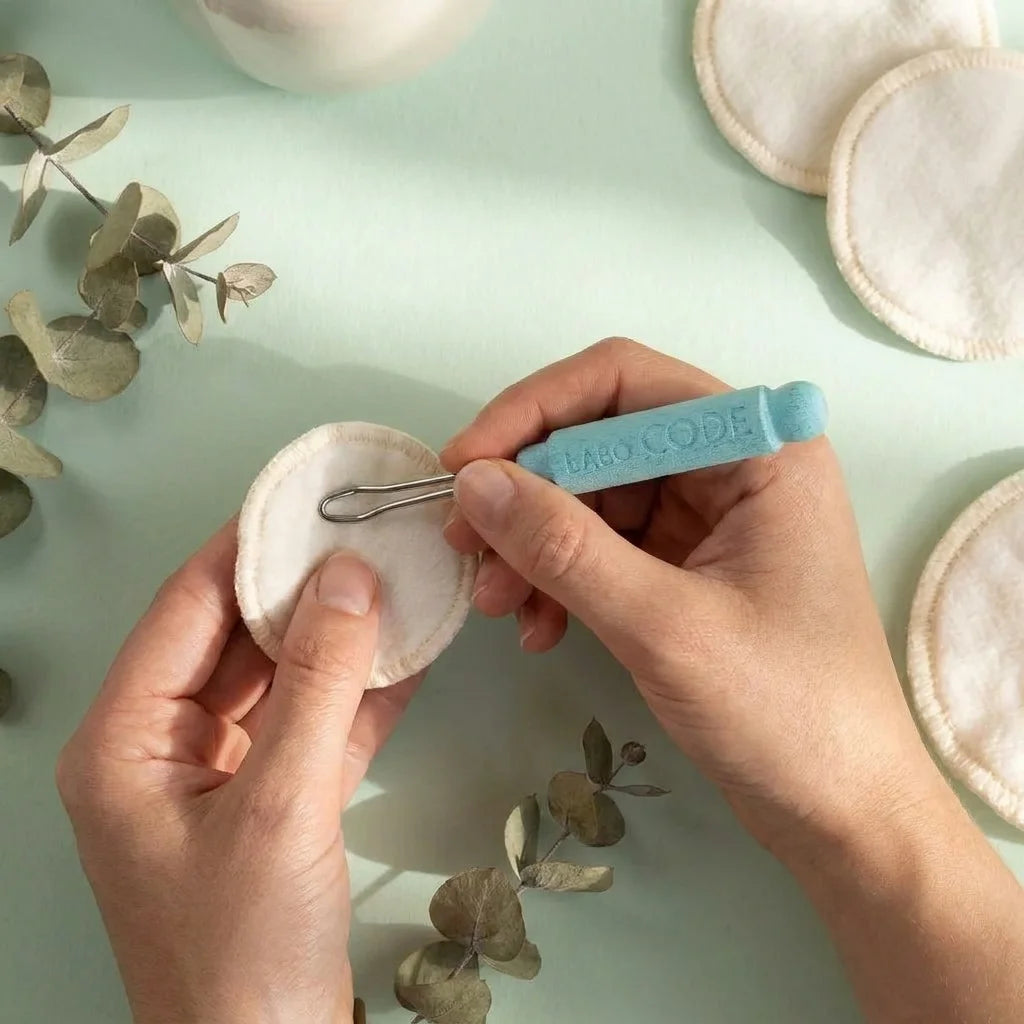 Cure-oreille réutilisable en acier inoxydable avec manche bleu ciel sur fond vert sage