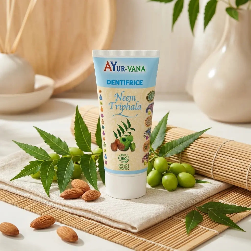 Dentifrice bio Neem & Triphala Ayurvana avec feuilles de neem et baies triphala sur fond naturel