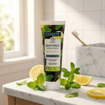 Dentifrice Charbon Végétal Coslys Bio avec menthe et citron sur marbre blanc