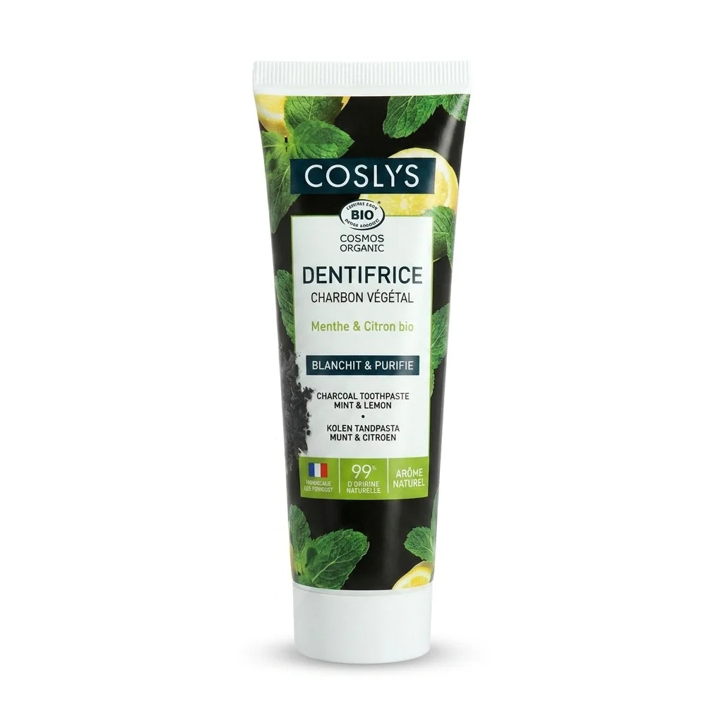 Tube de dentifrice charbon végétal bio Coslys, fond blanc, design noir et blanc avec feuille verte
