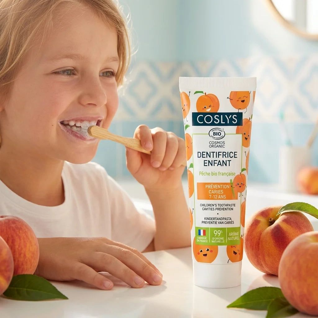 Dentifrice enfant pêche bio Coslys, enfant se brossant les dents en salle de bain moderne