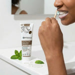 Dentifrice Bio blancheur Centifolia avec fluor, personne se brossant les dents avec mousse menthe fraîche