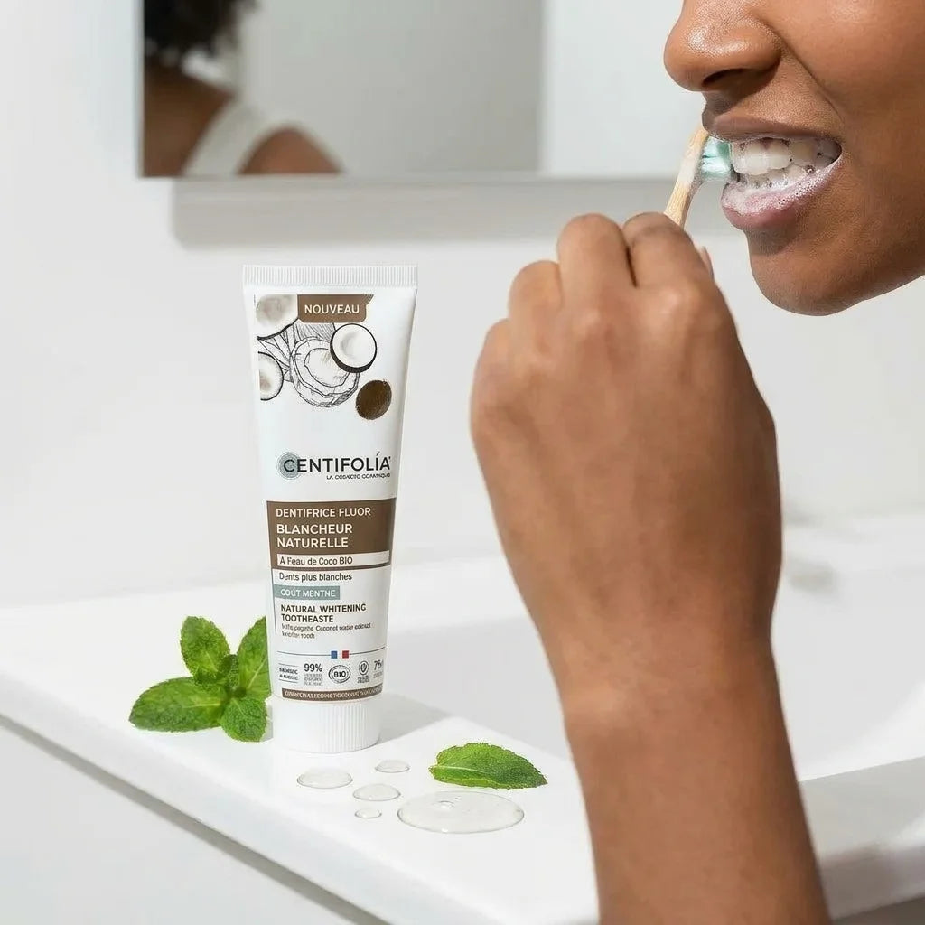 Dentifrice Bio blancheur Centifolia avec fluor, personne se brossant les dents avec mousse menthe fraîche