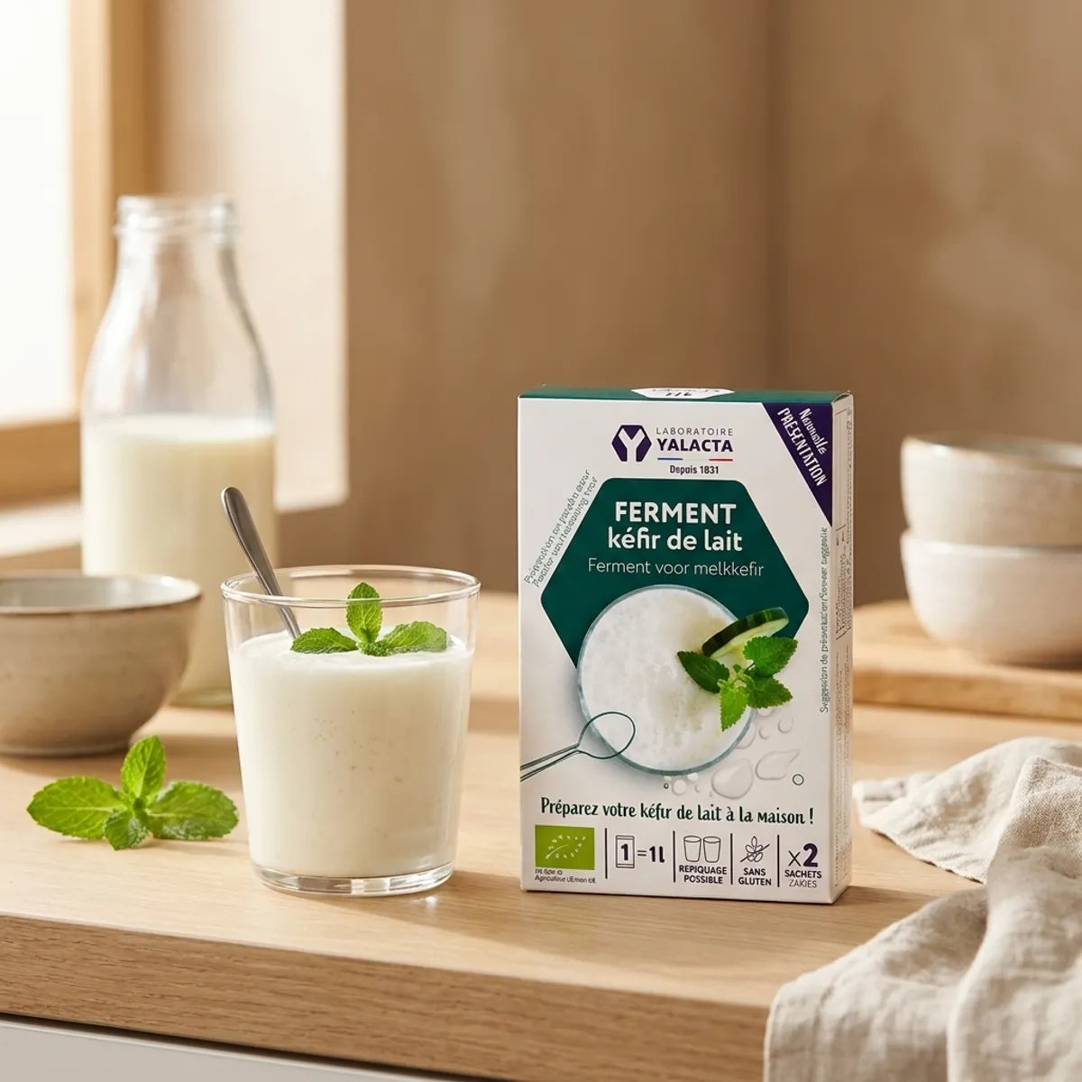 Ferment Kéfir de lait bio Yalacta avec verre de kéfir frais sur plan de travail cuisine