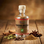 Pot de Garam Masala bio Ayurvana avec épices indiennes fraîches sur surface en bois