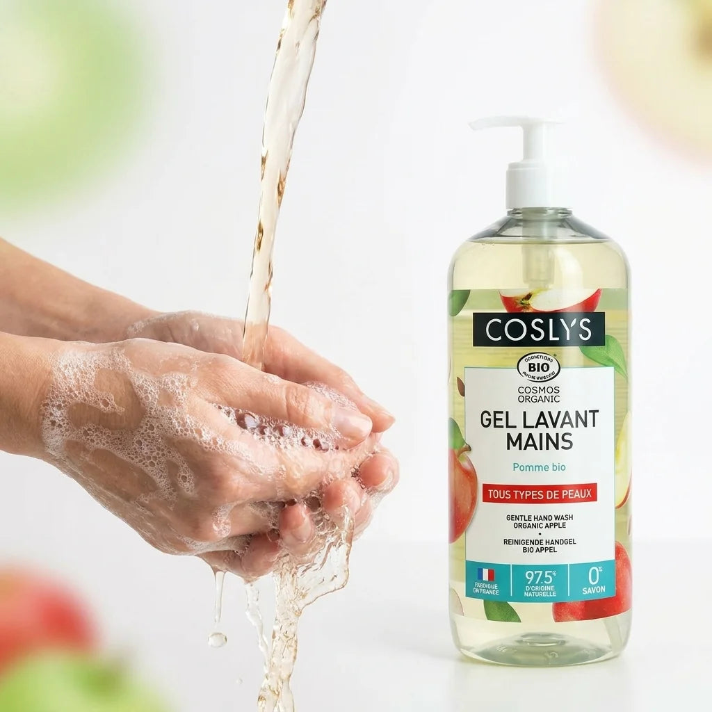 Gel lavant mains Coslys pomme bio, mains sous l'eau avec mousse, packaging visible