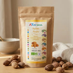 Poudre Haritaki Bio Ayurvana en sachet kraft avec fruits entiers sur surface en bois