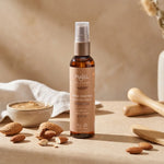 Huile d'amande douce Najel bio en flacon verre ambré avec pompe, amandes fraîches et accessoires wellness