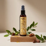 Bouteille d'huile de jojoba bio Najel avec branches naturelles sur surface bois