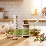 Huile essentielle d'ail Pranarom en flacon avec gousses d'ail frais en cuisine