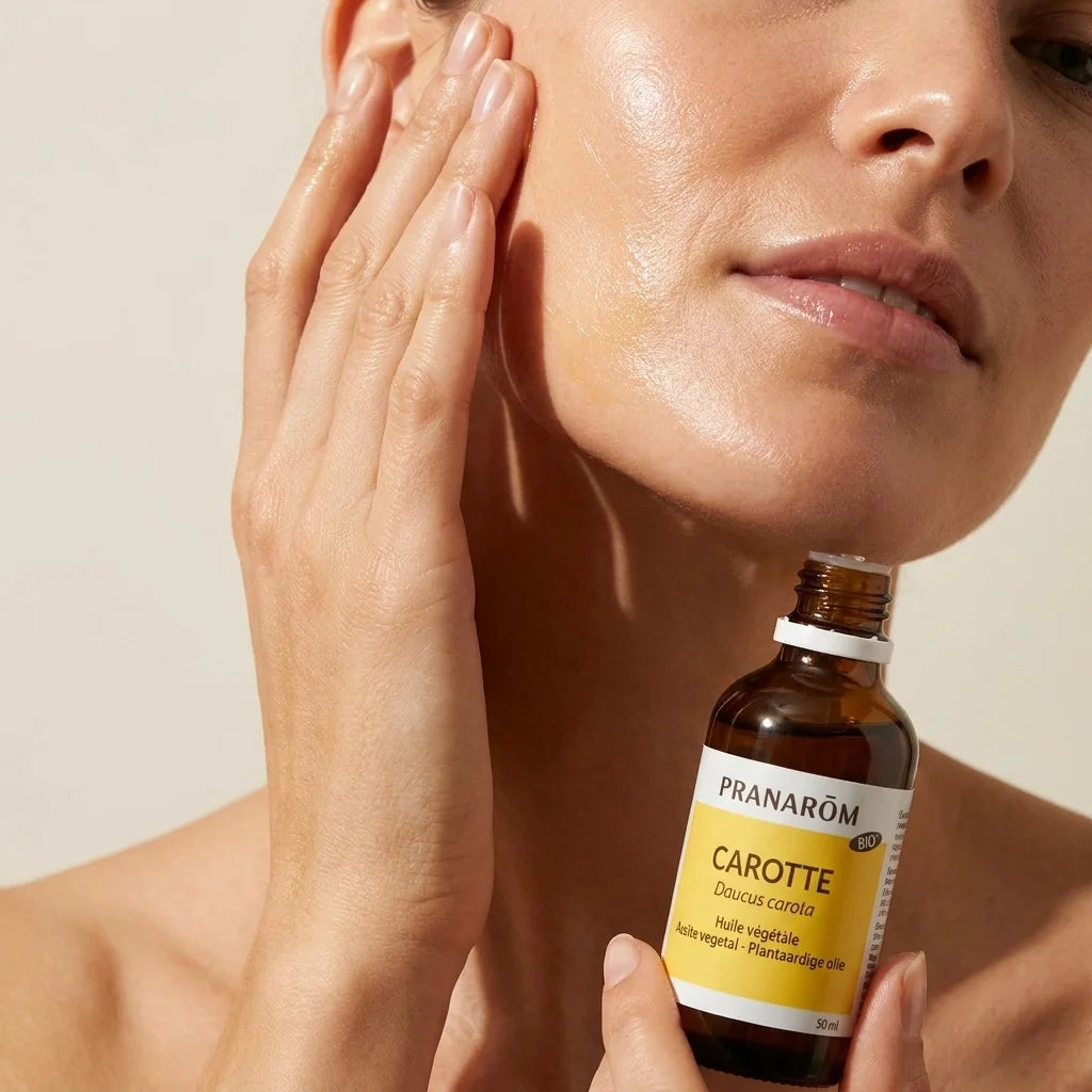 Huile végétale bio de carotte Pranarom appliquée sur la peau du visage et du cou
