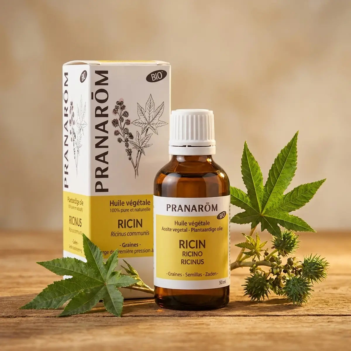 Huile végétale bio de ricin Pranarom 50ml sur surface bois avec feuilles fraîches