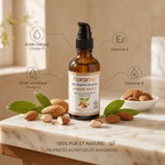 Huile d'amande douce Florame bio en flacon avec amandes et feuilles vertes sur marbre clair