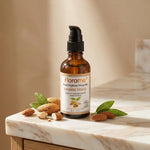 Huile d'amande douce bio Florame avec amandes fraîches et feuilles vertes sur marbre blanc