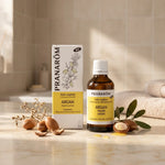 Huile d'argan bio Pranarom avec noix d'argan fraîches sur marbre blanc