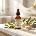 Huile végétale de jojoba bio Florame en flacon verre ambré sur marbre blanc avec branches de jojoba