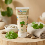 Lait corps Centella bio Ayurvana avec feuilles fraîches sur surface bois en ambiance spa