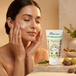 Femme appliquant le lait démaquillant Triphala bio Ayurvana sur son visage, peau lumineuse, tube produit visible