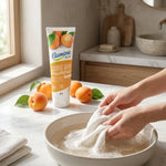 Lessive main hypoallergénique Etamine du Lys sur marbre avec abricots et mains lavant du linge