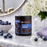 Masque Déjaunisseur Centifolia Bio en pot, entouré de myrtilles et fleurs blanches sur marbre