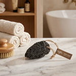 Pierre ponce Najel volcanique avec brosse bain et serviettes blanches sur marbre