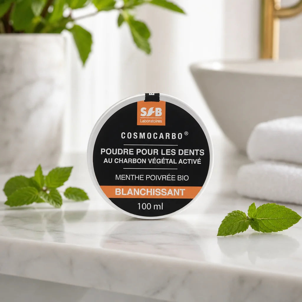 Poudre blanchissante menthe poivrée SFB 100ml sur vanité de salle de bain avec feuilles de menthe